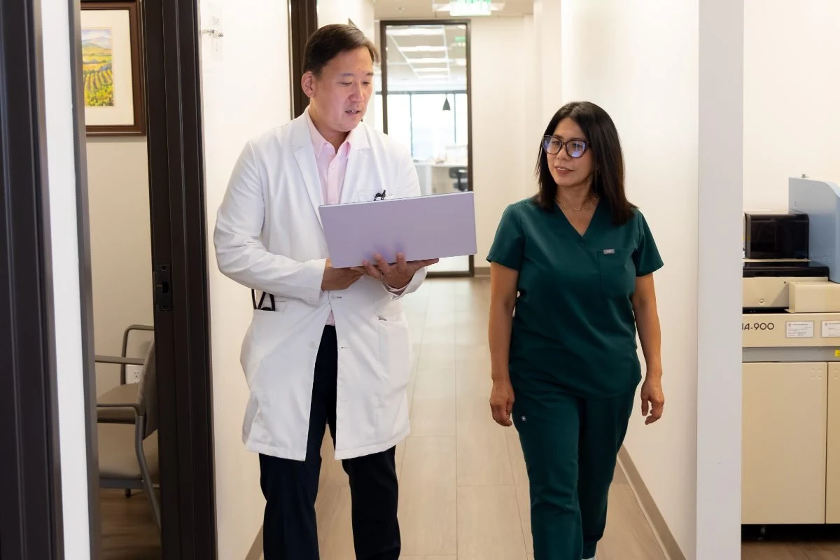 A Wellness Oncology physician and nurse walking together through the clinical corridor